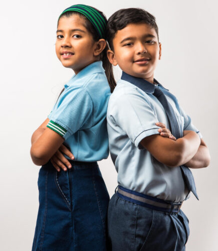 Cheerful Indian school kids in uniform standing isolated over white background